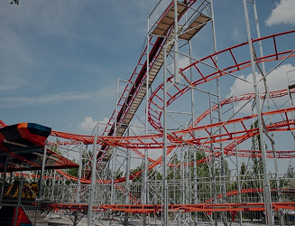 Roller coaster with red tracks in Central Park during the day