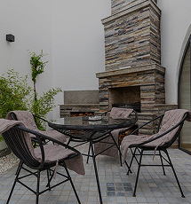 Outdoor terrace with fireplace and armchairs at The Choyxona restaurant