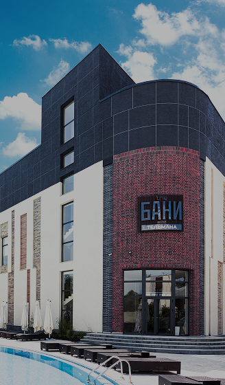 Facade of The BANI Tashkent bath complex with a pool in the foreground