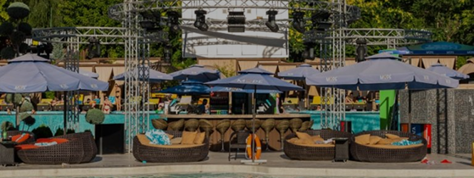 Lounge area with wicker furniture and a stage for daytime events at the 'More' complex