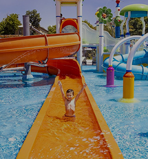 Child sliding down a colorful water slide in the kids’ area of the 'More' complex